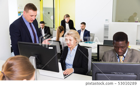 Business people working in open plan office Business people working in open plan office 53010289