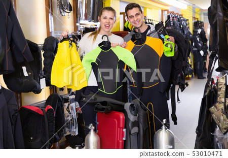 Man and woman are standing with modern diving equipment in the store. 53010471