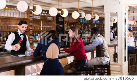 Happy people are relaxing near bar counter 53010560
