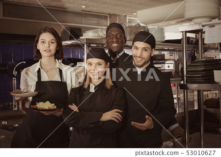 Woman waiter with command of cooks are posing together on kitche 53010627