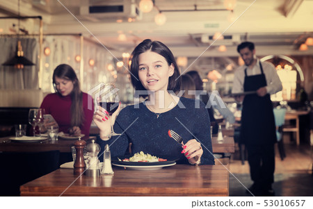 Woman enjoying dinner alone in restaurant Woman enjoying dinner alone in restaurant 53010657