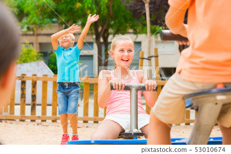 Company of kids are teetering on the swing Company of kids are teetering on the swing 53010674