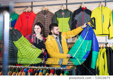 Couple examining windcheaters in store 53010675