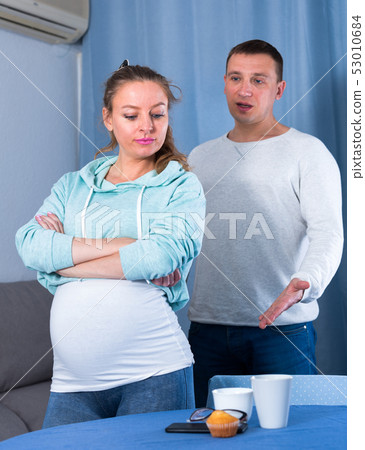 Husband and pregnant wife arguing at home Husband and pregnant wife arguing at home 53010684