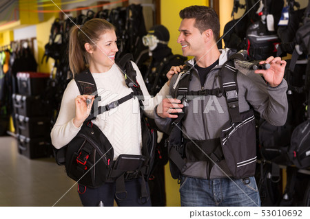 Male and woman standing in modern diving vest 53010692