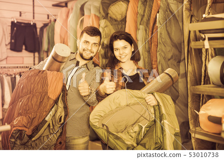 Young couple demonstrating tourist equipment Young couple demonstrating tourist equipment 53010738