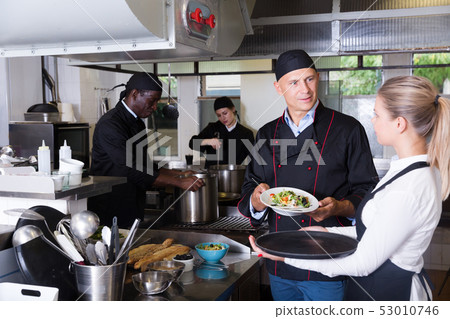 Chef checking dishes in kitchen Chef checking dishes in kitchen 53010746