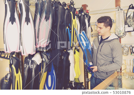 male is choosing new flippers for diving 53010876