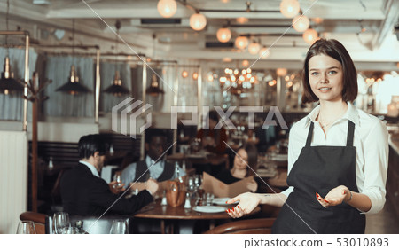 Portrait of smiling female waiter who is standing Portrait of smiling female waiter who is standing 53010893