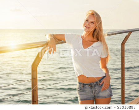 Elegant woman is posing on pirce in her free time Elegant woman is posing on pirce in her free time 53010895