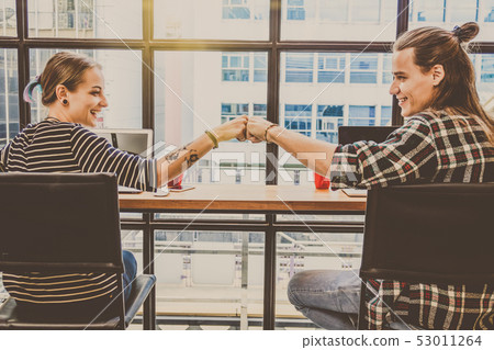 Hipster young couple freelancer Fist Bumping Corporate Colleagues Teamwork in the Loft cafe workplace. Creative Startup and entrepreneur business concept Hipster young couple freelancer Fist Bumping Corporate Colleagues Teamwork in the Loft cafe workplace. Creative Startup and entrepreneur business concept 53011264
