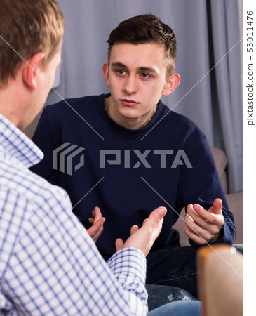 Man with his adult son are serious talking about life together 53011476