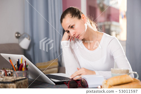 Tired woman working with laptop at the home 53011597