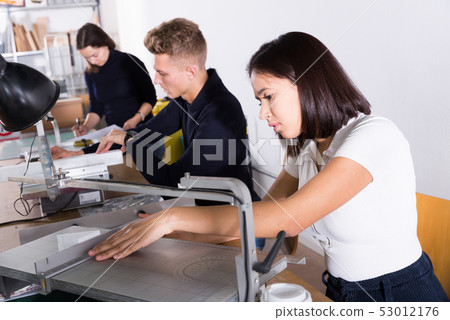 Female architect working on fret saw Female architect working on fret saw 53012176