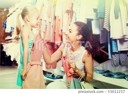 young woman and girl in clothes store. 53012257