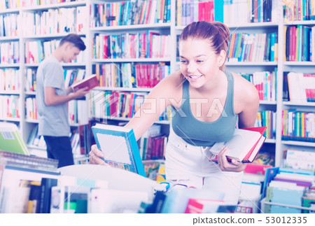 girl teenager choosing book in shop . girl teenager choosing book in shop . 53012335