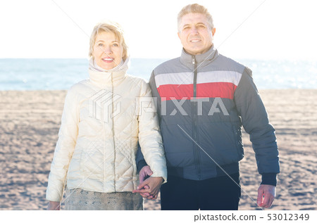 middle-aged husband and wife spend time together happily at sea beach 53012349