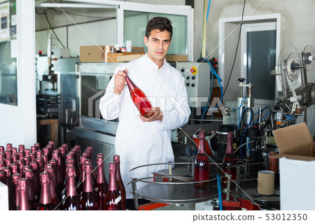 concentrated man employee standing in final section of wine production on factory concentrated man employee standing in final section of wine production on factory 53012350