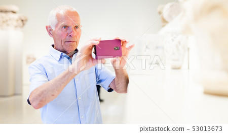 Man photographing sculptures in museum Man photographing sculptures in museum 53013673