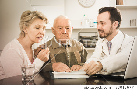 Old father with daughter visit doctor 53013677