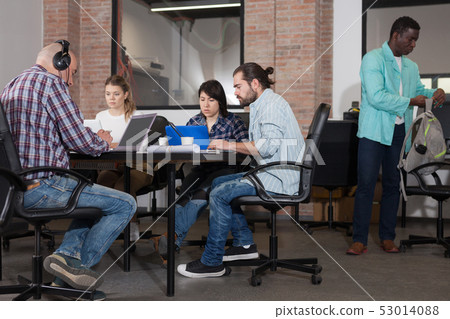 Young adults focused on work in office Young adults focused on work in office 53014088