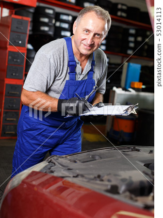 Car mechanic writing job sheet 53014113