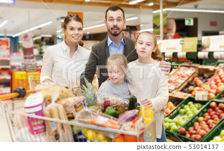 Family with daughters choosing meal for home in supermarket Family with daughters choosing meal for home in supermarket 53014137