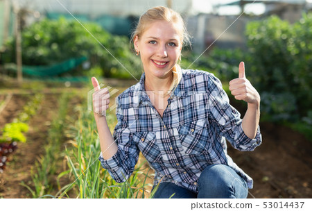 Girl in working wear at her garden 53014437