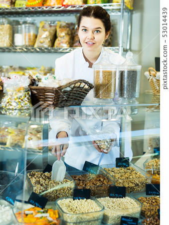 Girl offers a variety of nuts 53014439