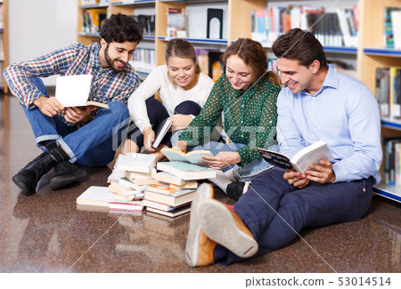 students sitting on floor in library in campus and preparing together for exams students sitting on floor in library in campus and preparing together for exams 53014514