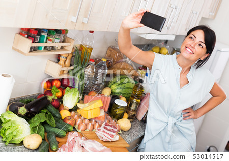 Female taking selfie in kitchen Female taking selfie in kitchen 53014517