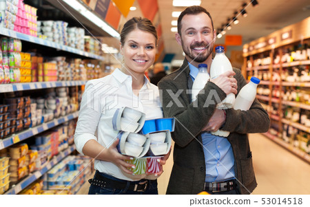 Couple buying milk in supermarket Couple buying milk in supermarket 53014518