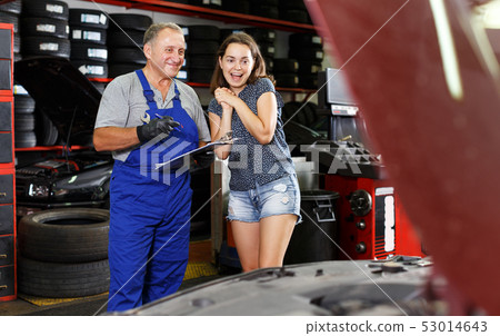 satisfied client with mechanician standing near her car after repairing satisfied client with mechanician standing near her car after repairing 53014643
