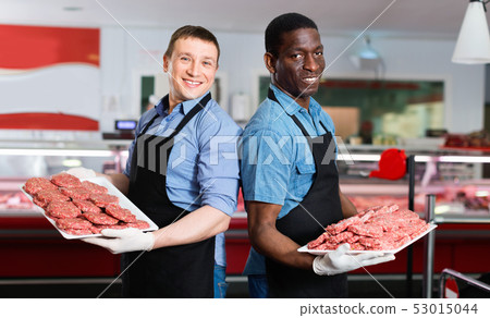 Successful sellers of butcher store offering fresh raw meat steak cutlets Successful sellers of butcher store offering fresh raw meat steak cutlets 53015044
