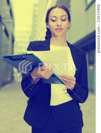 Woman is examining documents Woman is examining documents 53015408