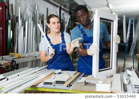 Two masters are working with window frame 53015440