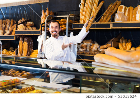 Seller offering fresh loaf of bread Seller offering fresh loaf of bread 53015624