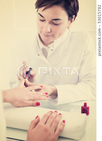 Woman doing manicure Woman doing manicure 53015782