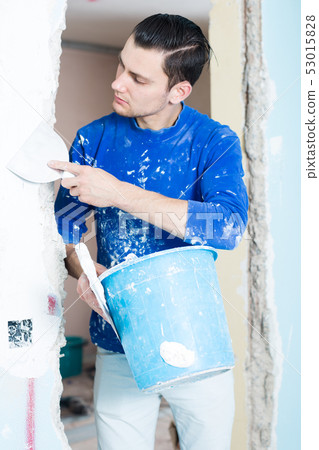 Man puttying doorway in apartment Man puttying doorway in apartment 53015828