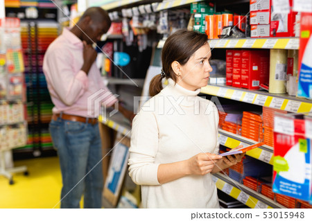 Portrait of woman choosing ball pen at stationery store Portrait of woman choosing ball pen at stationery store 53015948