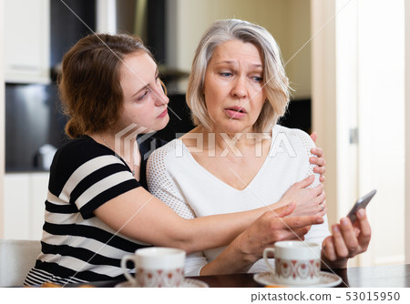 Upset women using smartphone Upset women using smartphone 53015950