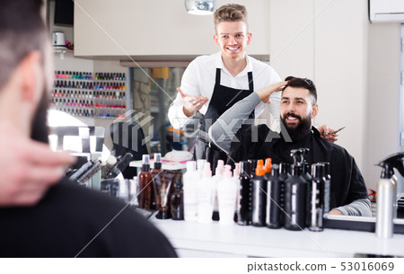 Cheerful client describing his desirable haircut Cheerful client describing his desirable haircut 53016069