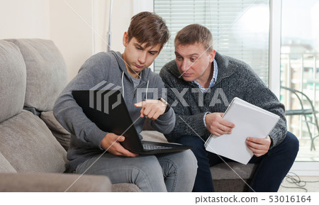 Guy with his father are resting and looking in notebook Guy with his father are resting and looking in notebook 53016164