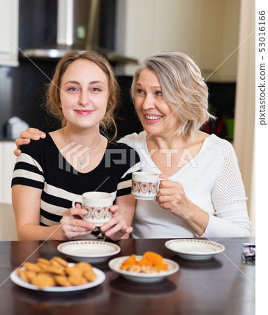 Two women talking at table Two women talking at table 53016166