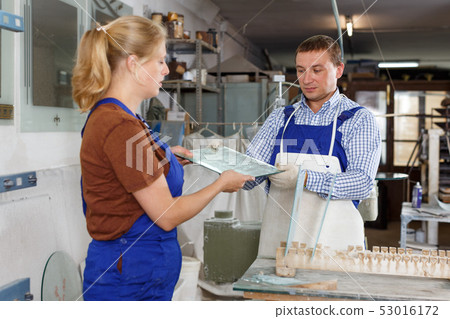 Man and woman working in glass workshop Man and woman working in glass workshop 53016172
