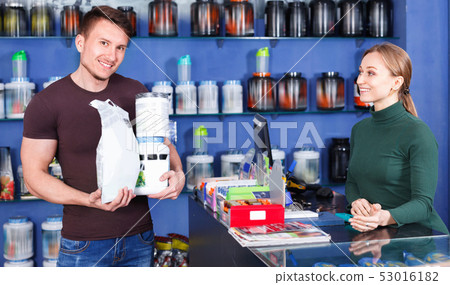 Athletic young man shopping for sport nutrition in store Athletic young man shopping for sport nutrition in store 53016182