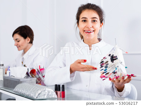 Female manicurist showing lacquer color schemes Female manicurist showing lacquer color schemes 53016217