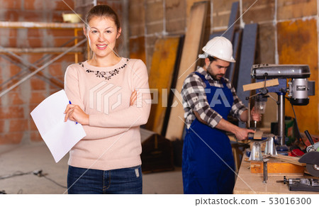 Architect with drawing checks the work of builders Architect with drawing checks the work of builders 53016300