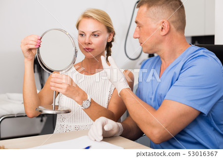Dermatologist is consulting to female patient about her skin of face Dermatologist is consulting to female patient about her skin of face 53016367