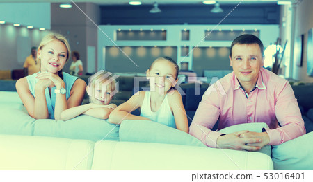 Family are choosing new sofa in furniture store. Family are choosing new sofa in furniture store. 53016401